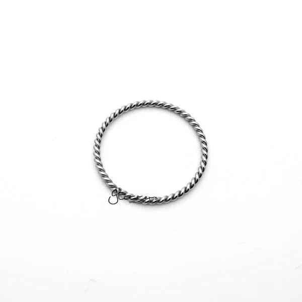 Twisted stainless steel women's ring in silver by Glitters, showcasing a sleek, modern design and polished finish.