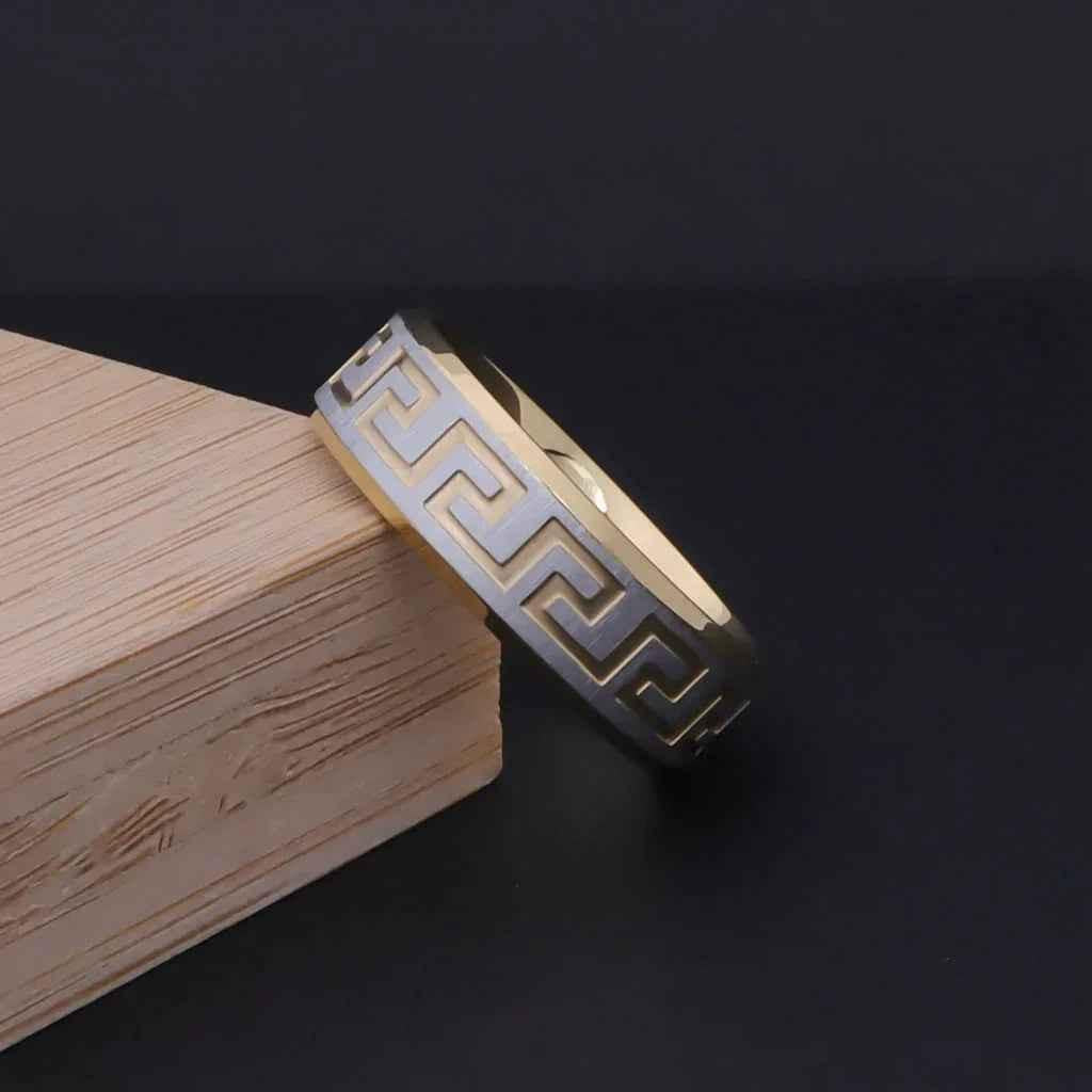 Stainless steel ring by Glitters, 8mm wide, two-tone Greek key design with a matte finish, featuring intricate metal accents.