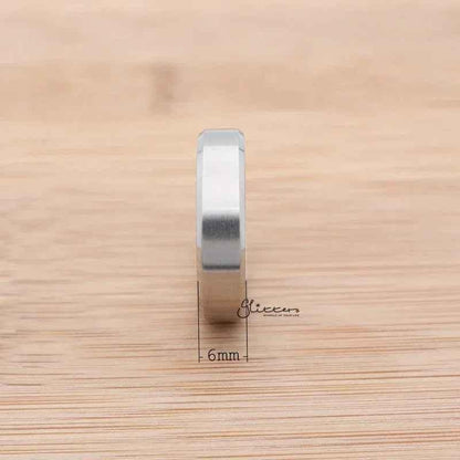 Silver stainless steel 6mm wide beveled edge band ring from Glitters, showcasing a sleek, modern design.