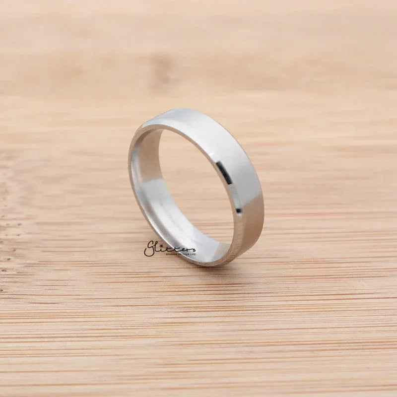 Silver stainless steel 6mm wide beveled edge band ring from Glitters, showcasing a sleek, polished design and smooth beveled edges.