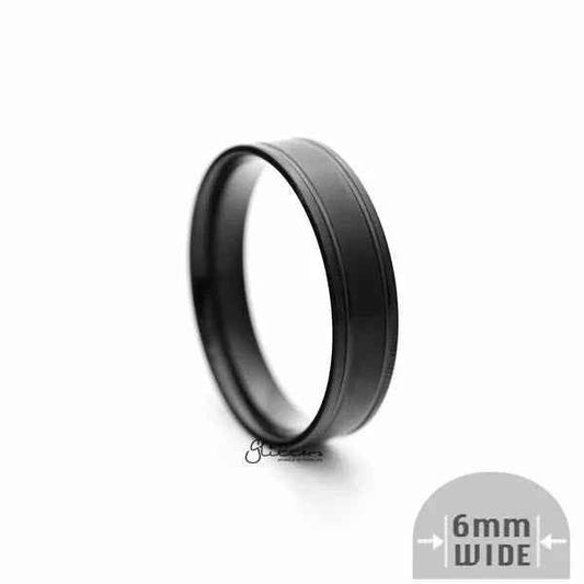 Black stainless steel 6mm wide brushed center band ring by Glitters, showcasing a sleek, modern design with a polished finish.
