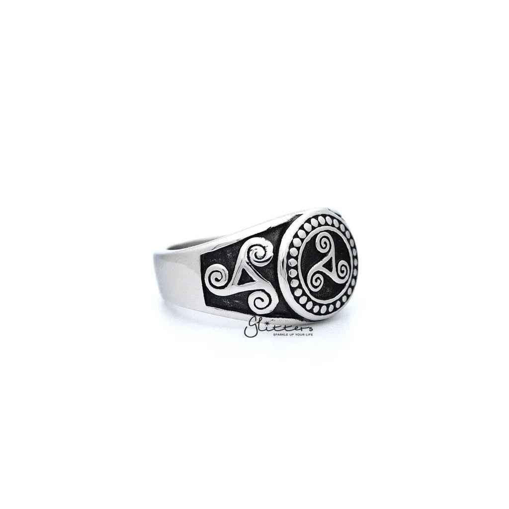 Stainless steel men's ring with antiqued triskele and triple spiral design, featuring detailed casting from Glitters.
