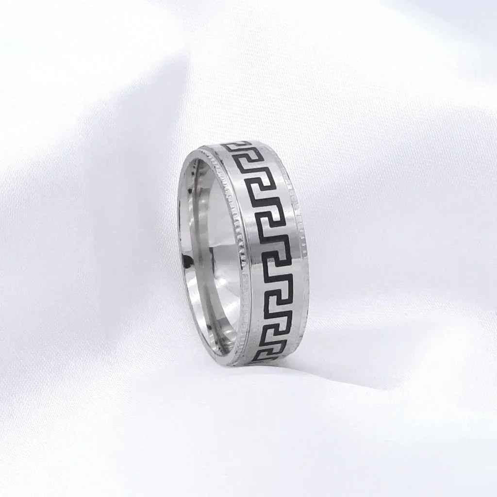 Silver stainless steel Greek key pattern band ring by Glitters, featuring intricate geometric design on smooth silver surface.