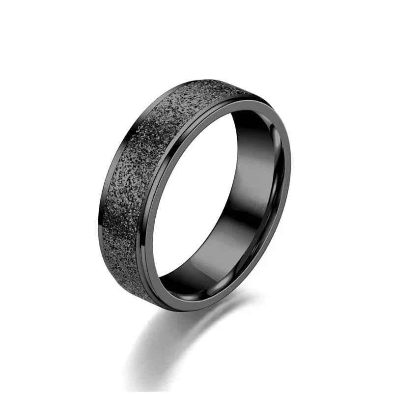 Black stainless steel band ring with sandblasted finish, designed by Glitters, showcasing a sleek and modern jewelry style.