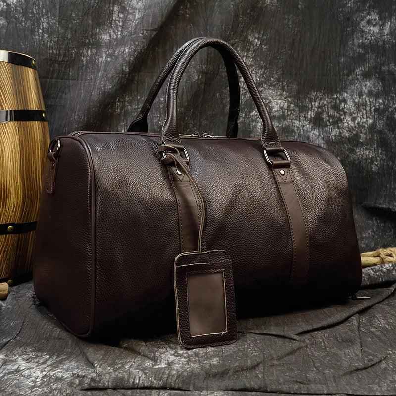 Leather business travel bag by Mead's Supply & Equipment Outfitters, black and bronze, with multiple compartments and sturdy handle.