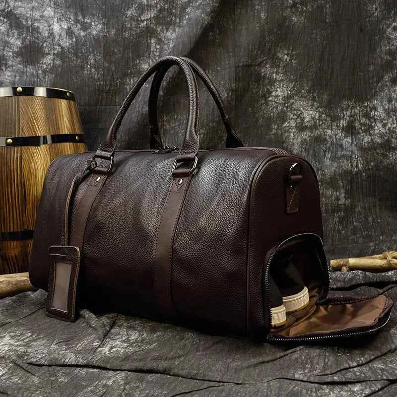 Leather business travel bag by Mead's Supply & Equipment Outfitters, black and bronze duffel with multiple compartments and sturdy handles.