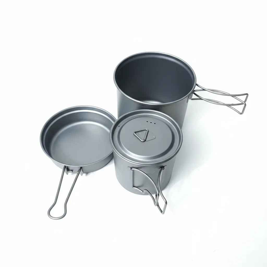 Titanium camping cookware set with ultralight 1100ml pot and 350ml pan, folding handles, by Mead's Supply & Equipment Outfitters.