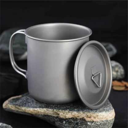 Titanium folding camping cup with lid, ultralight collapsible travel mug for outdoor camping and hiking by Mead's Supply.