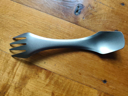 Titanium 3-in-1 camping utensil from Mead's Supply & Equipment, ultralight spork with knife edge for outdoor camping gear.