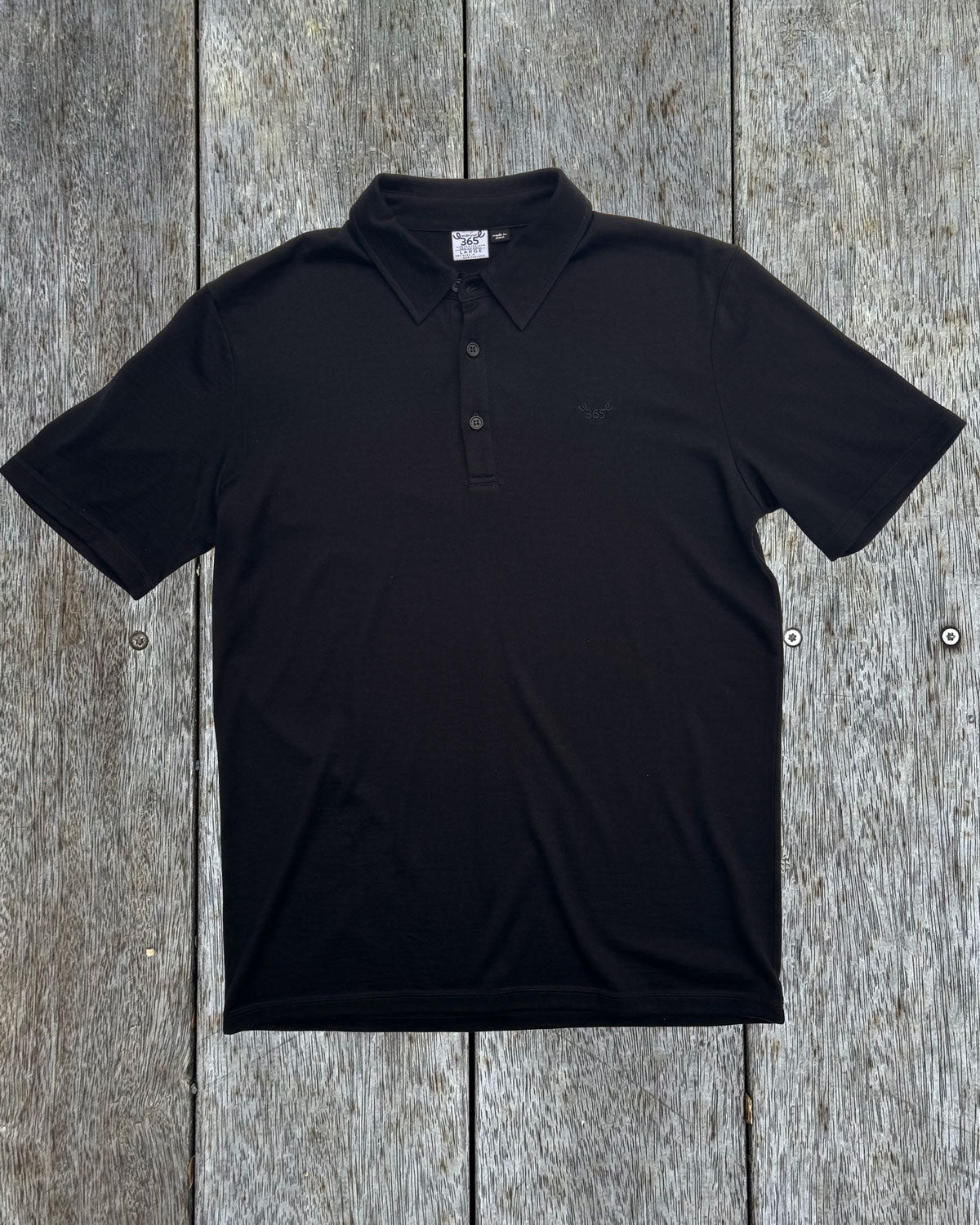 Men's black polo shirt made from 100% Merino Wool by Merino 365 NZ, showing a classic polo collar and soft fabric.