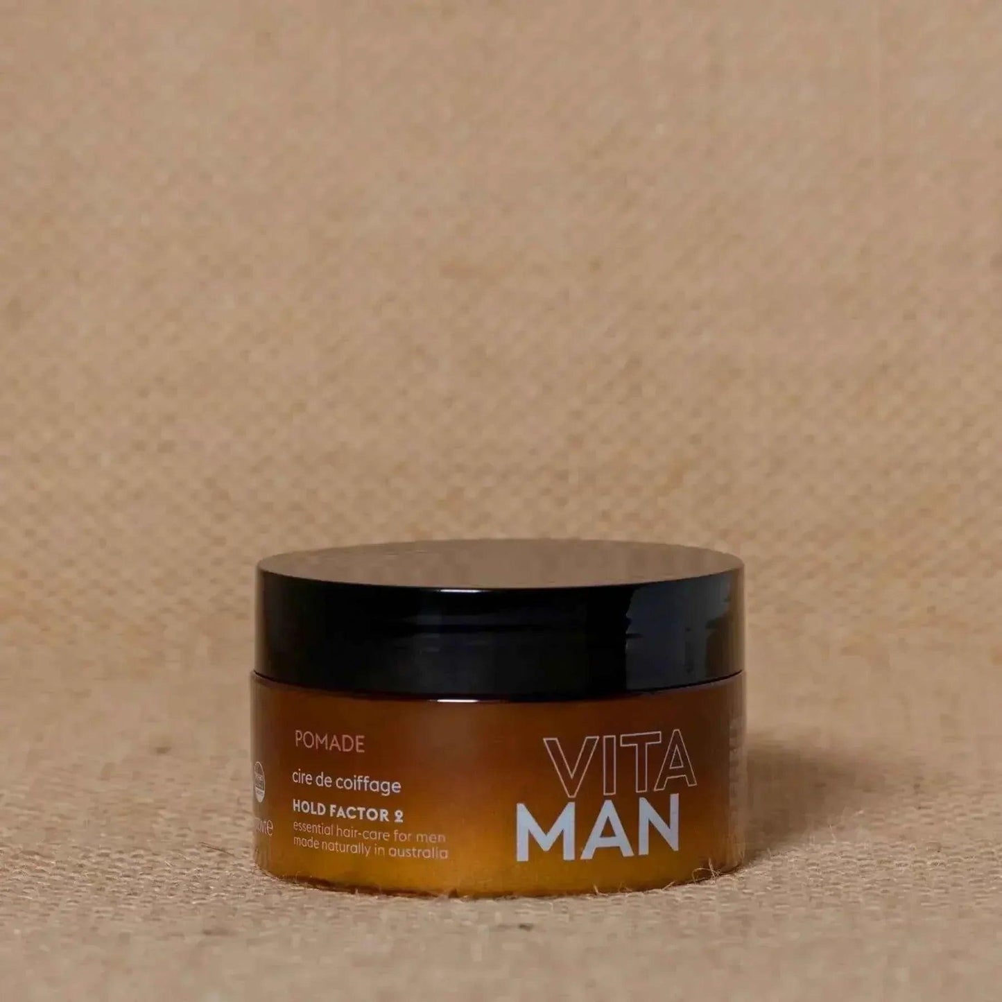 VITAMAN Australia hair pomade 100g jar with black lid, smooth texture for styling hair, shown on a white background.