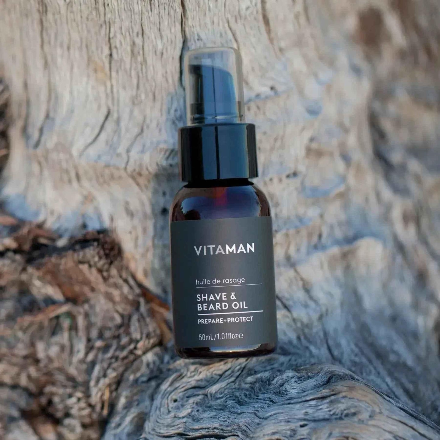 VITAMAN Australia shave and beard oil bottle and applicator for grooming and beard care in a natural setting.