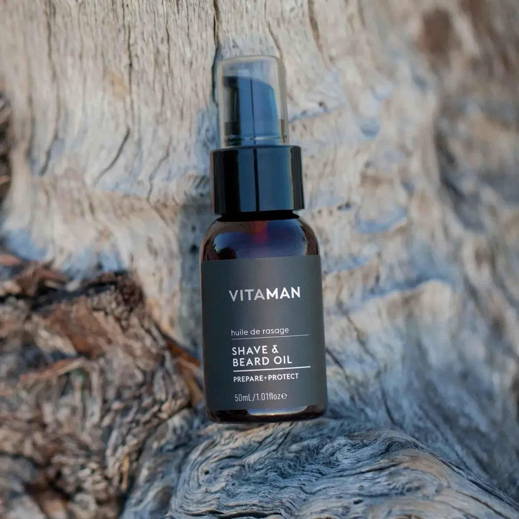 VITAMAN Australia shave and beard oil bottle and applicator for grooming and beard care in a natural setting.