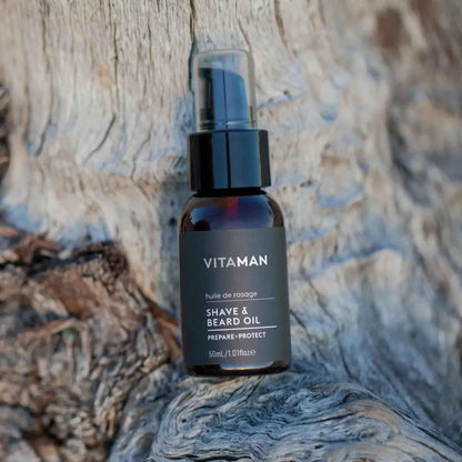 VITAMAN Australia shave and beard oil bottle and applicator for grooming and beard care in a natural setting.